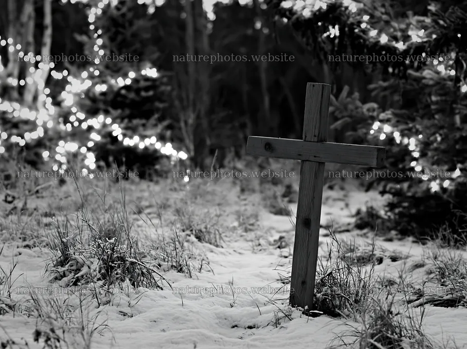 Christian cross stands in snowy meadow with lights in background – nature photos 9174x6866
