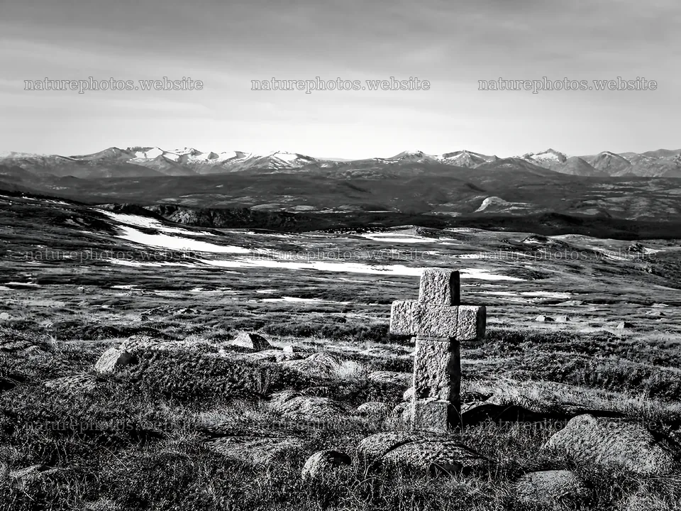 Christian cross in deep mountain valley during winter – nature photos 9166x6874