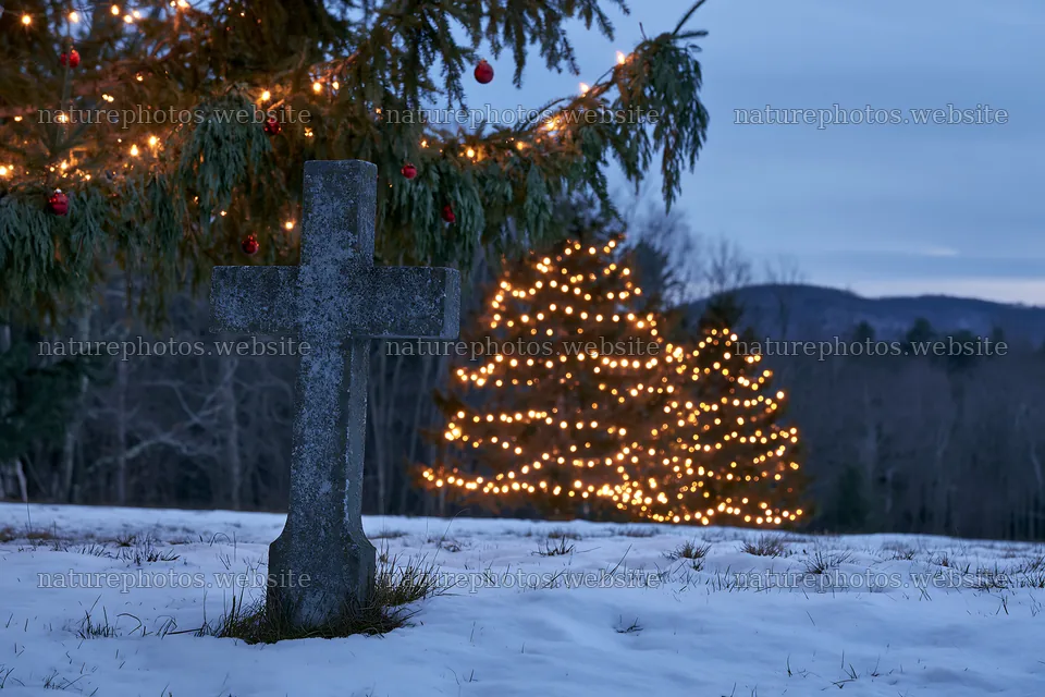 Weathered Christian cross in snowy meadow with lit trees – nature photos 9722x6480